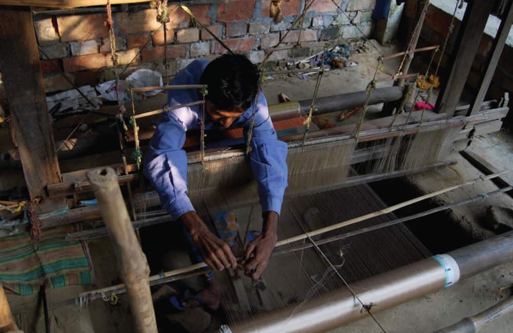 Weaving-man-adjusting-loom