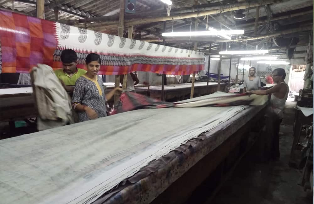 Laying out fabric for screen printing at Brindaban Prints