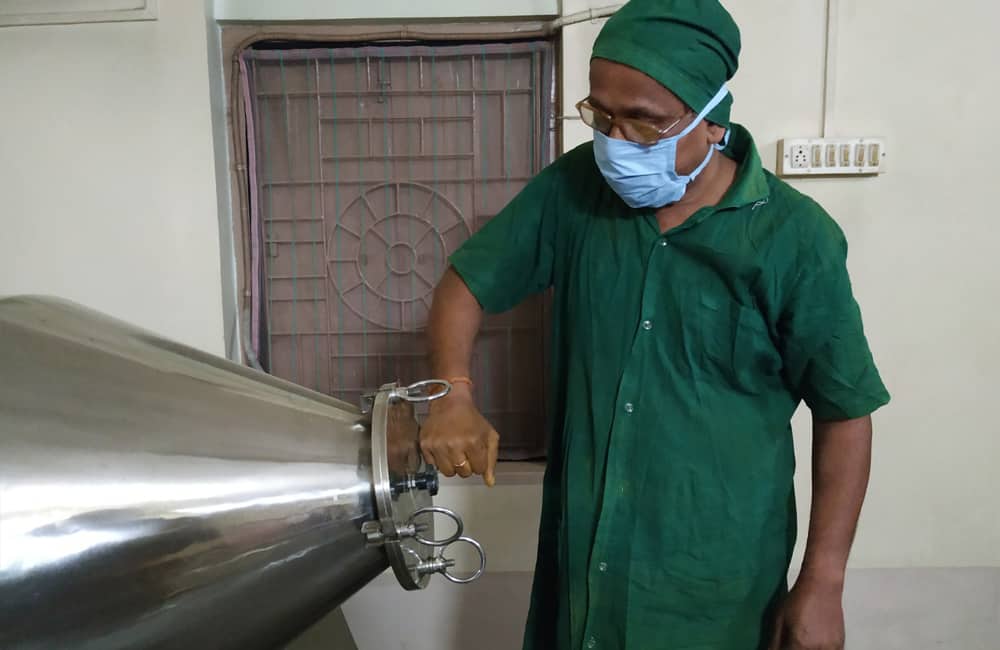 Worker at RASA production facility creating natural body care products