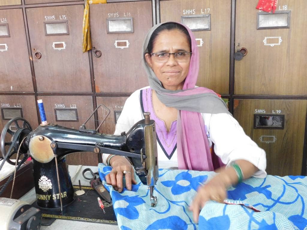 Woman sitting at a treadle sewing machine